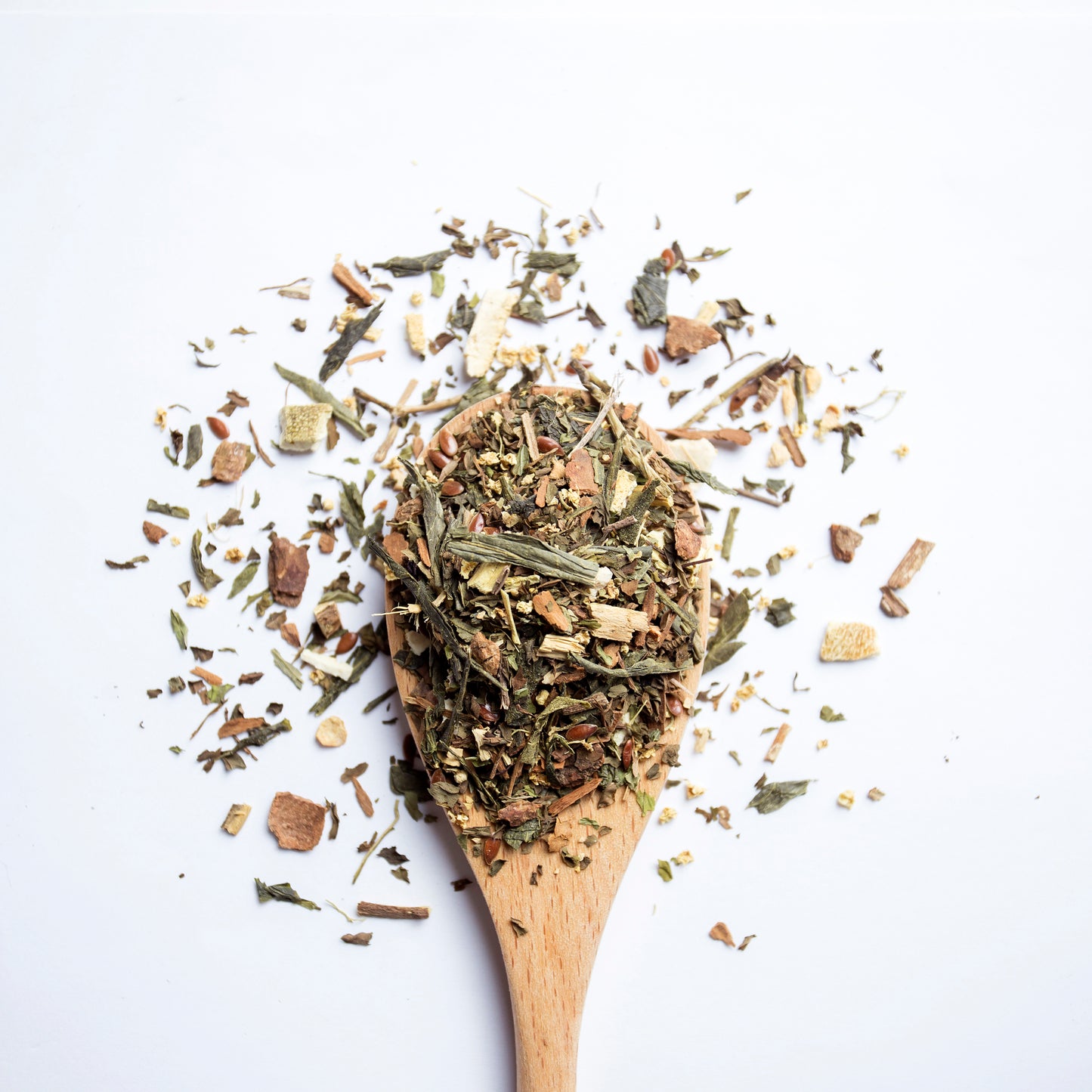 The Custodian calming sencha green tea blend for digestion and inflammation support, with soothing herbal notes of mint and citrus in A wooden spoon