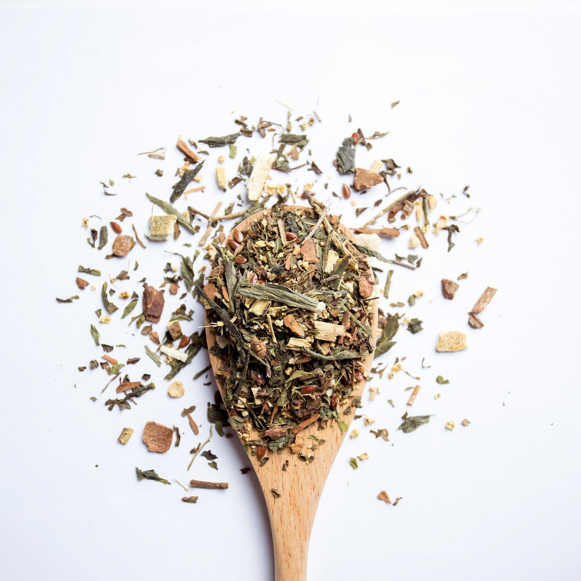 The Custodian calming sencha green tea blend for digestion and inflammation support, with soothing herbal notes of mint and citrus in A wooden spoon